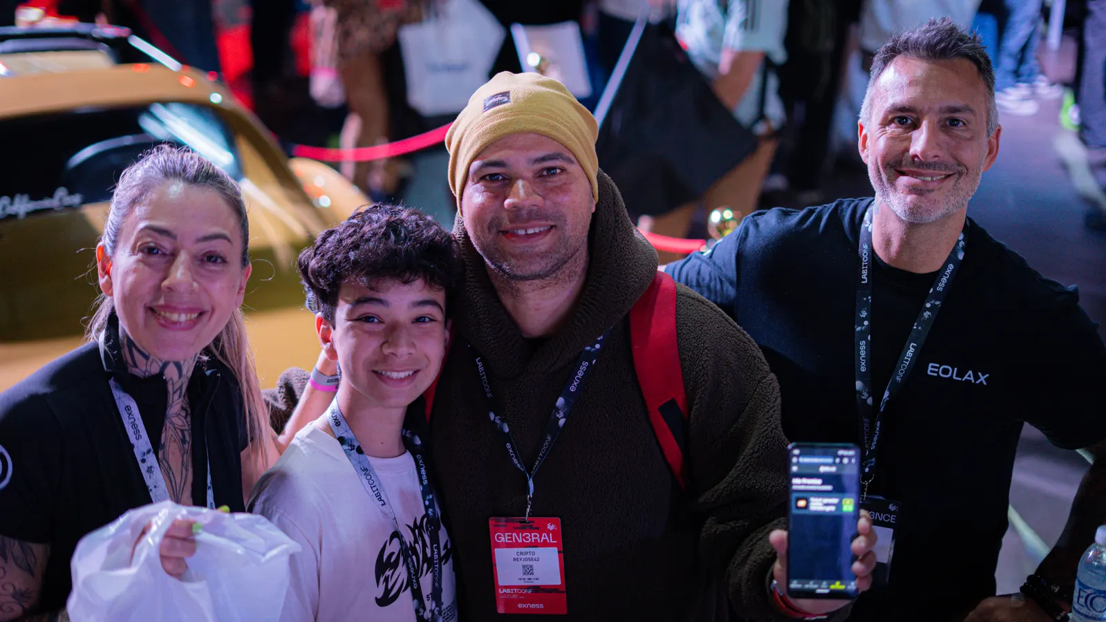 The winners of the Tienda Cripto bag pose with the Eolax team: one holds the bag, the other shows the prize already credited in the app.