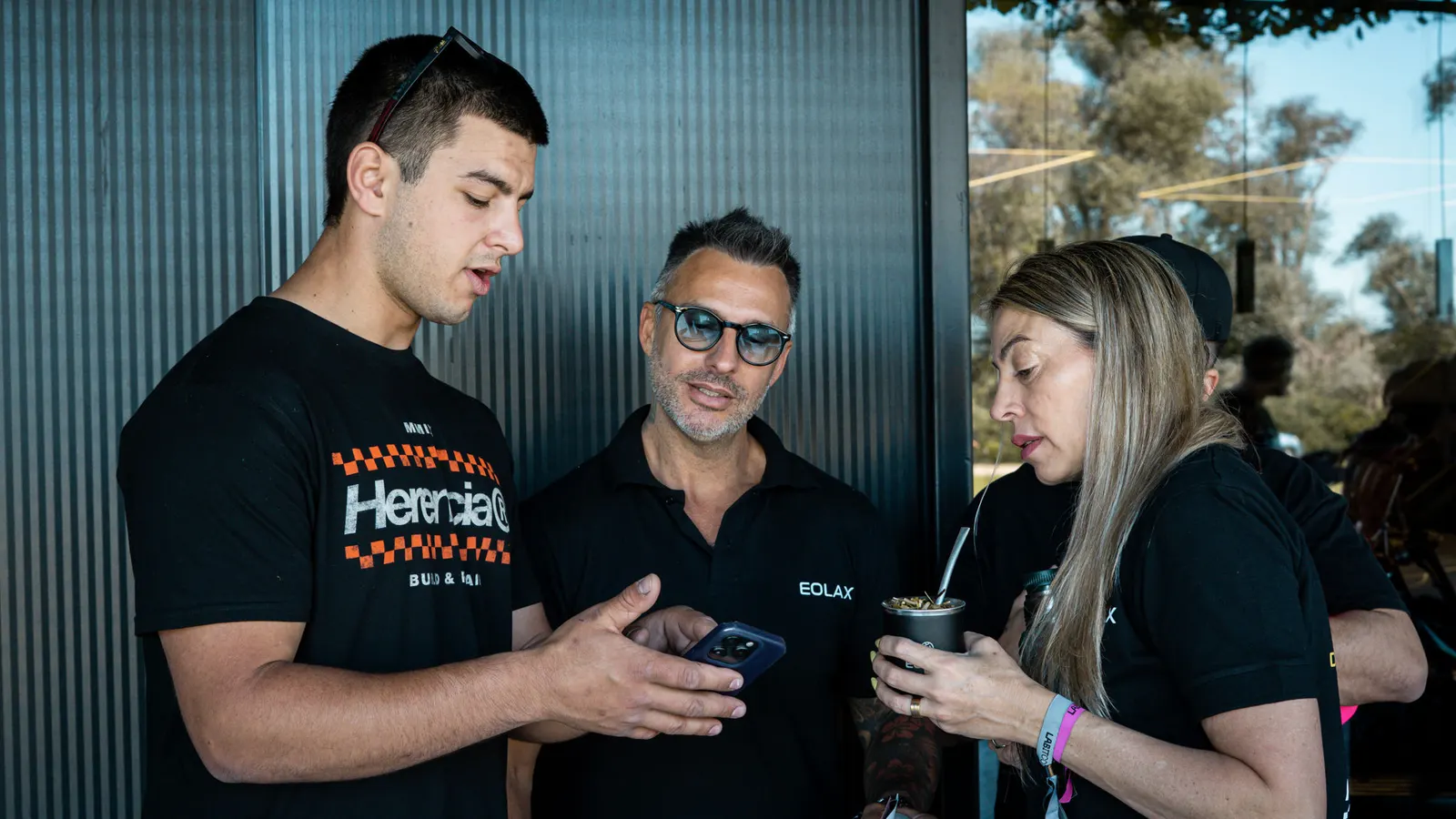 A guest shows the oxeo ticket on his phone to two members of the Eolax team.